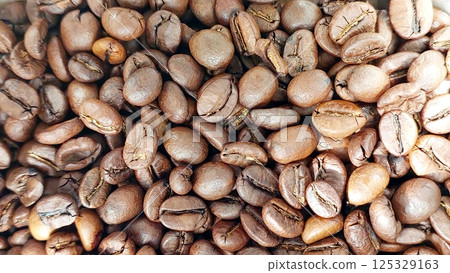 Coffee beans in a close view showcasing their rich texture and various shades of brown Coffee beans in a close view showcasing their rich texture and various shades of brown 125329163