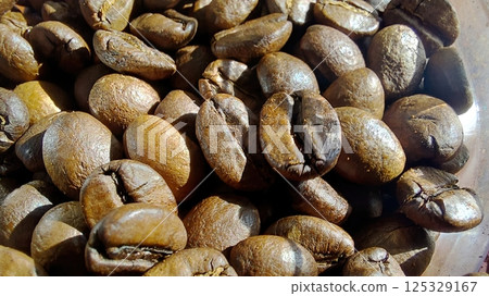 Dark roasted coffee beans ready for brewing in a rustic setting 125329167