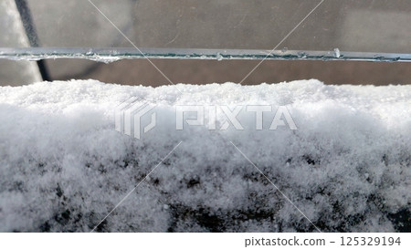 Snow-covered glass revealing a tranquil winter landscape in a quiet neighborhood Snow-covered glass revealing a tranquil winter landscape in a quiet neighborhood 125329194