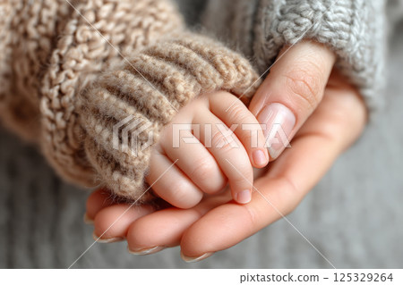 Tender moment of mother and baby hands together 125329264