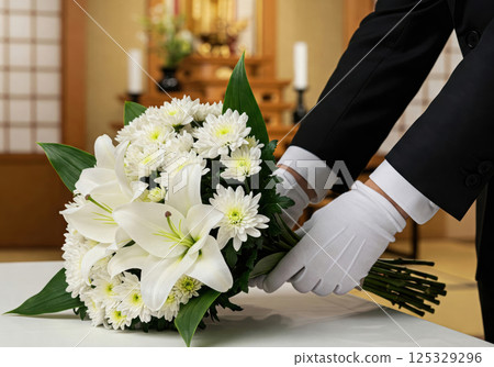 一名殯儀館工作人員正在佈置白色鮮花（人工智慧生成的圖像） 125329296
