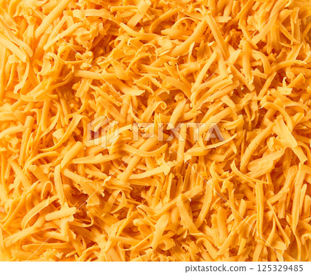 Grated cheddar cheese close up background. 125329485
