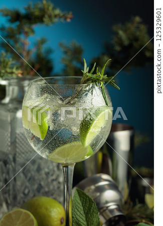 Cocktail gin and tonic with ice and lime slices in wet glass. 125329601
