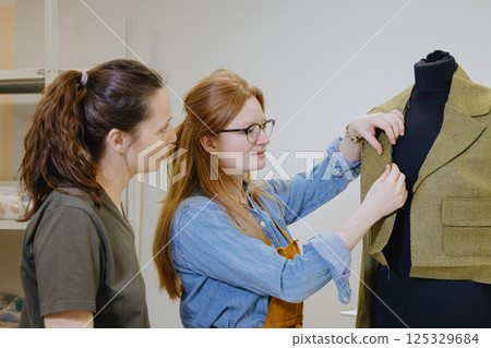 Atelier sewing workshop. female seamstress, fashion designer, takes measurements . Atelier sewing workshop. female seamstress, fashion designer, takes measurements . 125329684