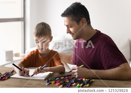 Bonding young single dad tween son draw sketches with markers 125329828