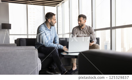 Two men engaged in formal discussion in modern office Two men engaged in formal discussion in modern office 125329837