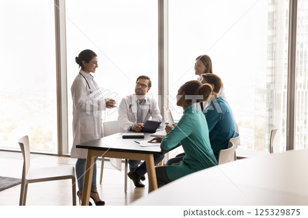 Millennial woman doctor experienced professional talking with young medic interns 125329875