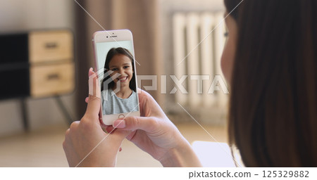 Cute girl talking to mother using videocall app 125329882