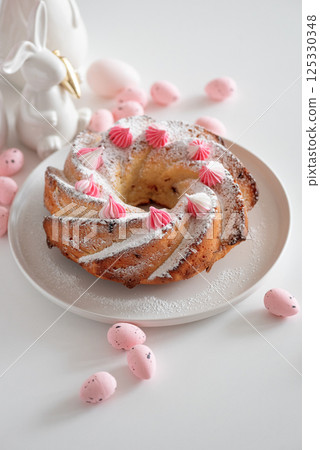 Traditional Easter cakes with icing decorated candies on white wooden table Traditional Easter cakes with icing decorated candies on white wooden table 125330348