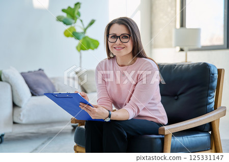 Portrait of professional psychologist therapist woman with clipboard in office Portrait of professional psychologist therapist woman with clipboard in office 125331147