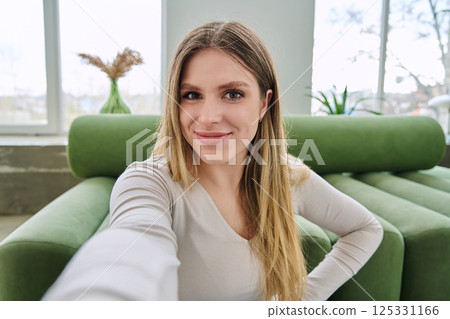 Selfie portrait happy beautiful young woman in home interior 125331166