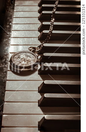 Perspective of Retro pocket watch or Antique pocket watch on Piano keys background. 125331314