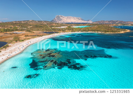 Aerial view of white sandy beach with umbrellas, luxury yachts 125331985