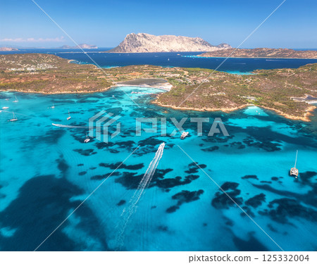 Aerial view of luxury yachts and boats on blue sea, island 125332004