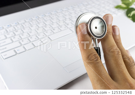 筆記型電腦、手和聽診器。電腦故障的圖像 筆記型電腦、手和聽診器。電腦故障的圖像 125332548
