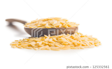 Orzo, kritharaki, risoni pasta. Uncooked dry pasta in spoon isolated on white background. Orzo, kritharaki, risoni pasta. Uncooked dry pasta in spoon isolated on white background. 125332561