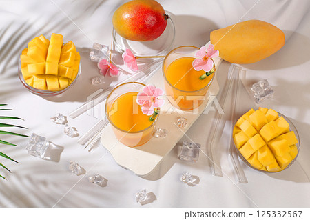 Cold homemade lemonade cocktail, juice or smoothie with mango, ice and fruits on sunny table, refreshing summer drink recipe, detox diet and weight loss concept, restaurant menu 125332567