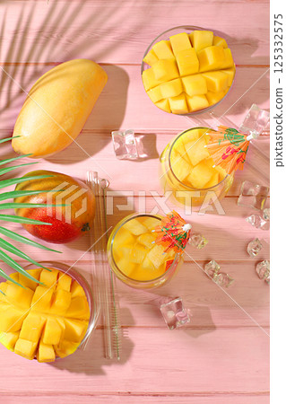 Summer party concept. Homemade cocktail, juice or lemonade with mango slices and ice on sunny kitchen table. Refreshing summer diet drink recipe, Detox diet and healthy lifestyle, Restaurant menu, 125332575
