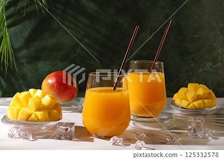 Cold homemade lemonade cocktail, juice or smoothie with mango, ice and fruits on dark table, refreshing summer drink recipe, detox diet and weight loss concept, restaurant menu 125332578