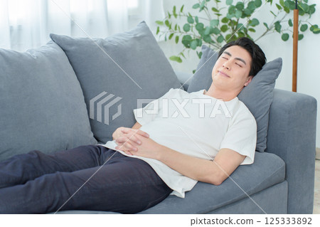 Man taking a nap on the sofa Man taking a nap on the sofa 125333892