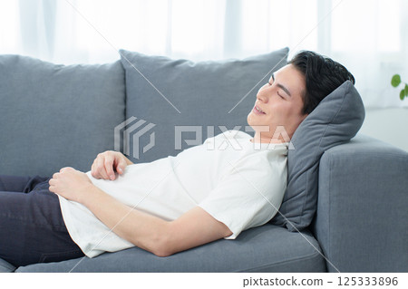 Man taking a nap on the sofa Man taking a nap on the sofa 125333896