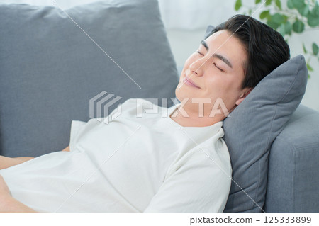 Man taking a nap on the sofa 125333899