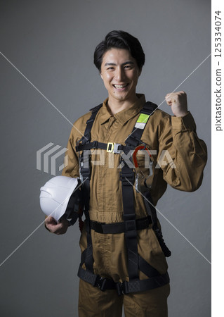 Male worker wearing a full harness Male worker wearing a full harness 125334074