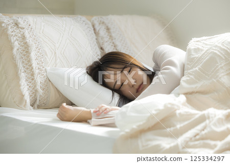 A young woman sleeping in bed A young woman sleeping in bed 125334297