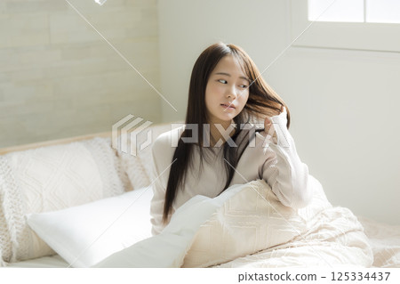 A woman watching a smartphone in bed 125334437