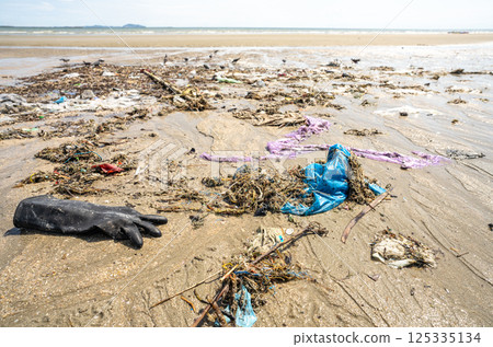 Human waste covers a tropical beach with plastic bags and debris scattered along the coastline. Global crisis of marine pollution and environmental contamination. Beach pollution crisis. Ocean waste. 125335134