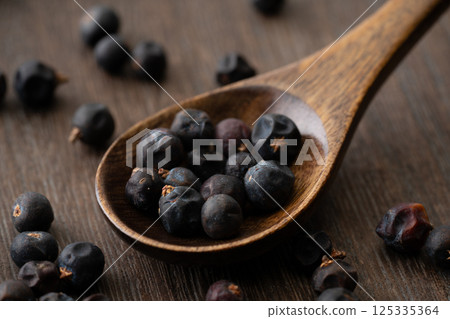 Close-up of juniper berries on a wooden spoon 125335364