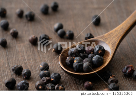 Close-up of juniper berries on a wooden spoon 125335365