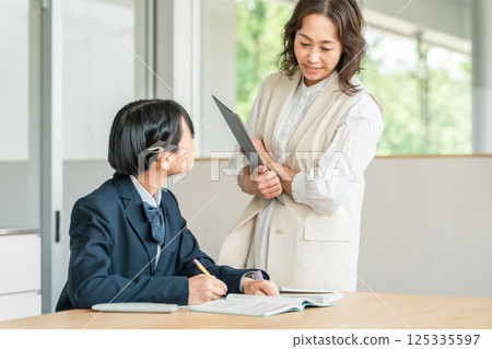 Teacher, instructor, female lecturer and female student studying in school, cram school classroom 125335597