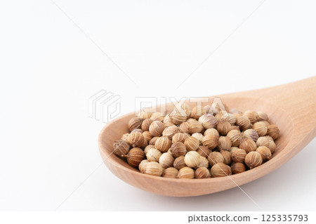 Close-up of coriander seeds on a wooden spoon 125335793