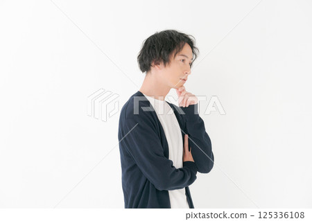 A man in his 30s standing with his arms folded 125336108