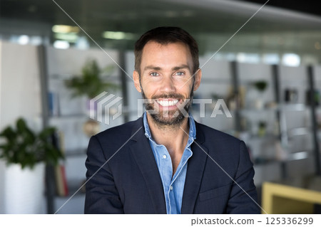 Businessman looking at camera, exuding confidence and professionalism, office portrait 125336299
