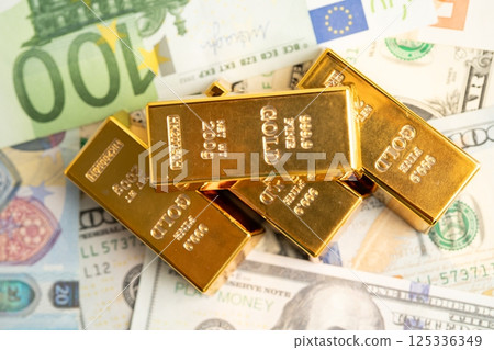 Gold bar on US dollar and Euro banknote, economy finance exchange trade investment. 125336349