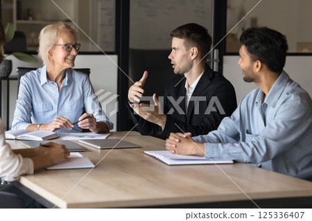 Young business professional man speaking at board meeting Young business professional man speaking at board meeting 125336407