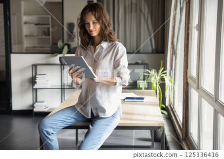 Successful busy businesswoman works using digital tablet tech 125336416