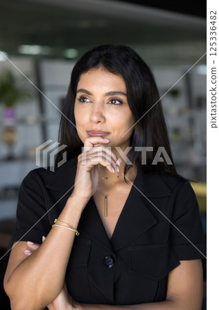 Woman looks aside with thoughtful expression, vertical office portrait Woman looks aside with thoughtful expression, vertical office portrait 125336482