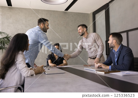Two young businessmen shaking hands, gesture of agreement or collaboration 125336523