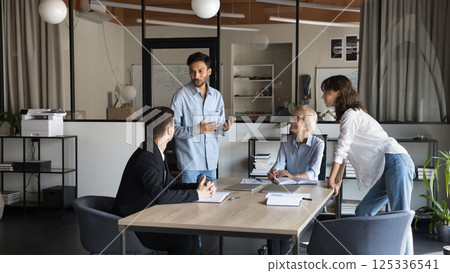 Happy Indian male leader coaching diverse business people 125336541
