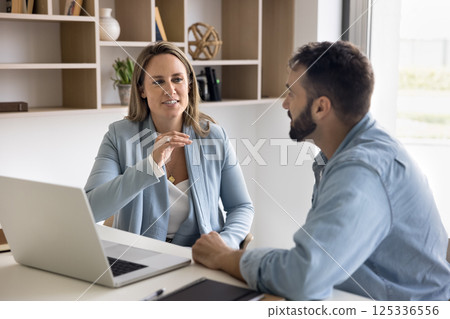 Mature female consultant give advice to male client in office Mature female consultant give advice to male client in office 125336556