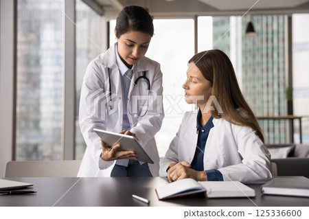 Young female medic worker intern get professional consultation from mentor 125336600