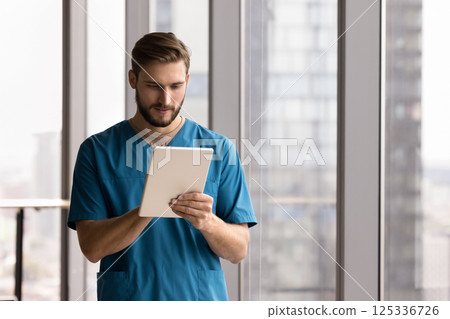 Young man doctor surgeon reading data on digital tablet Young man doctor surgeon reading data on digital tablet 125336726