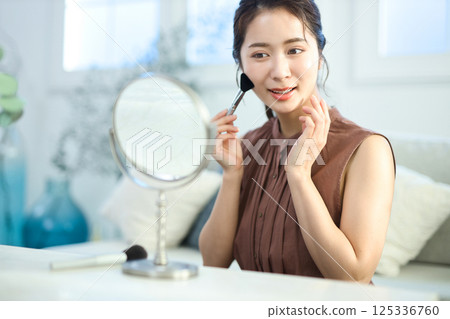 一位年輕的女士化妝 一位年輕的女士化妝 125336760