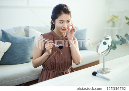 一位年輕的女士化妝 一位年輕的女士化妝 125336762