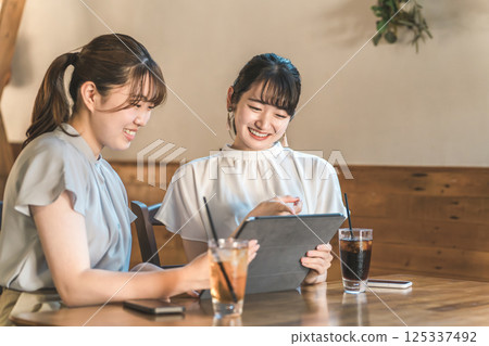 女性顧客在咖啡館、餐廳或小餐館按菜單點菜 女性顧客在咖啡館、餐廳或小餐館按菜單點菜 125337492