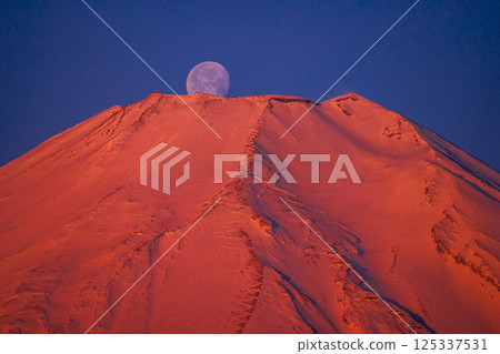 The moon setting over the crimson peak of Mount Fuji 125337531