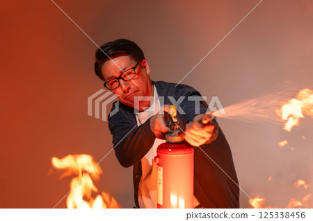 Man spraying a fire extinguisher 125338456